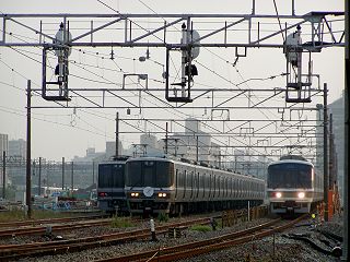 鷹取で待機する臨時列車用車両（207系，223系）と通過する221系回送